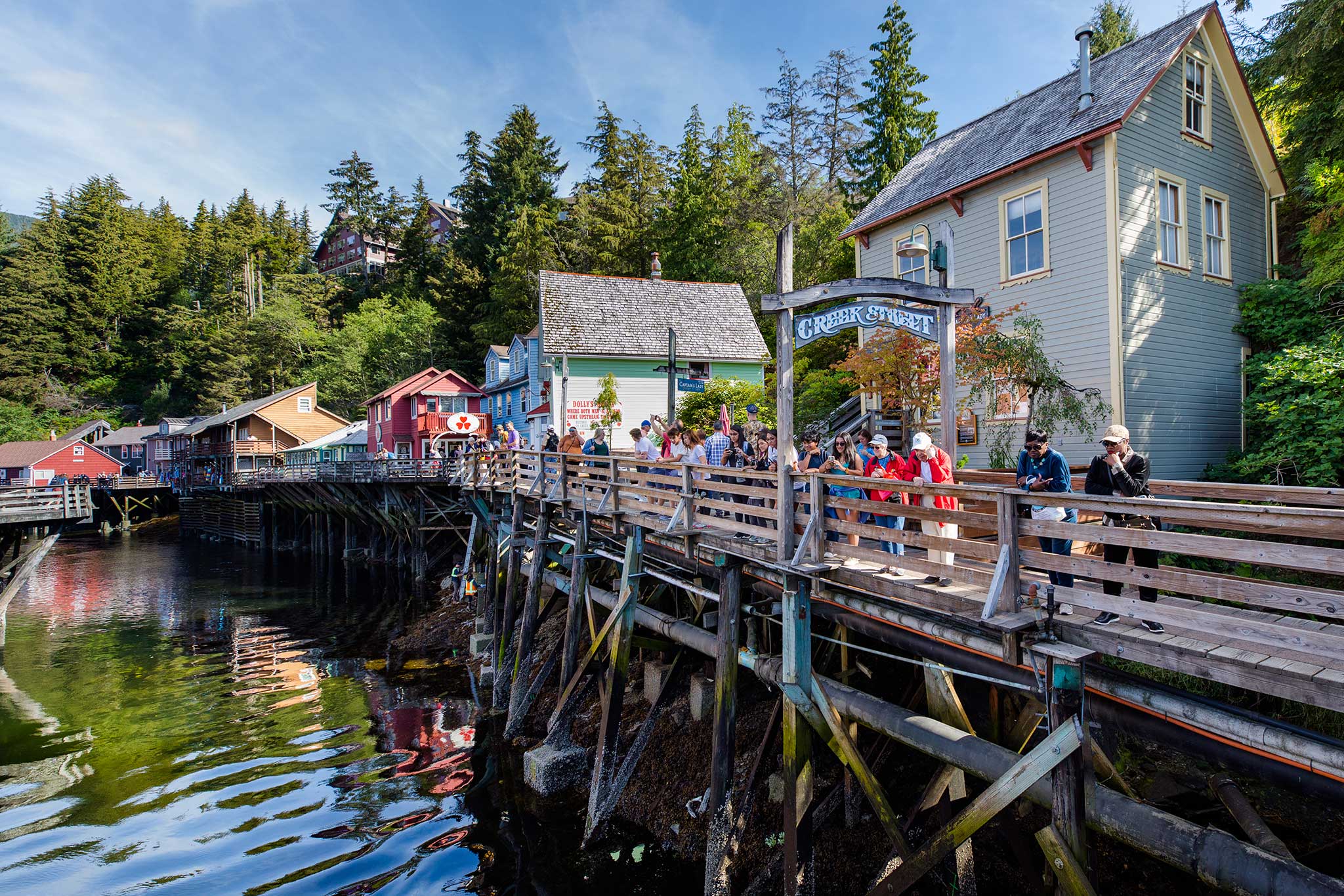 Scenic view of Creek Street in Ketchikan, featuring colorful wooden buildings on stilts above water.