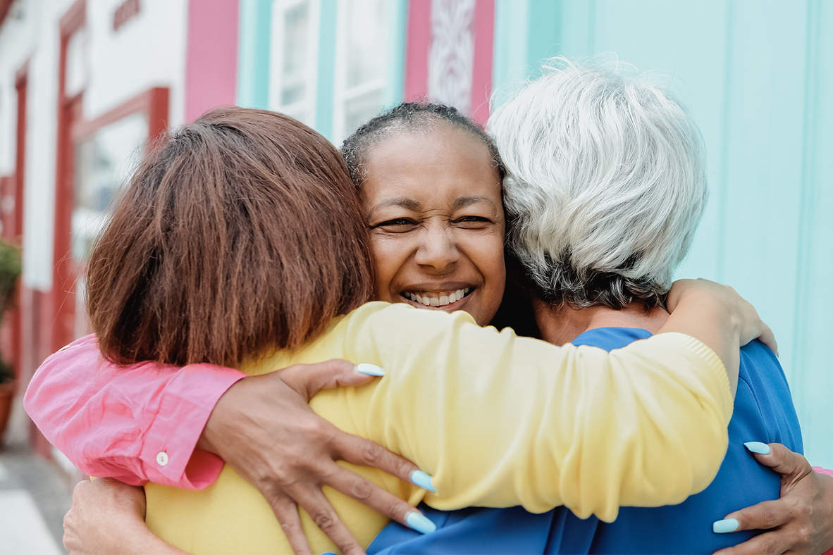 A smiling woman hugging two other women