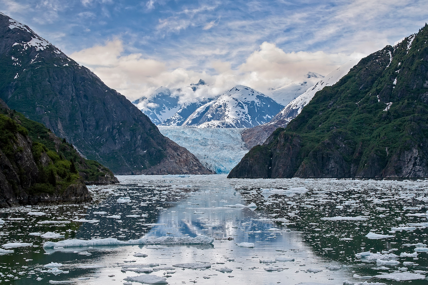 South Sawyer Glacier in Tracy Arm Fjord, Alaska, surrounded by snow-capped mountains and floating ice in a scenic fjord.