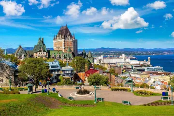 Scenic overlook of Quebec City’s skyline with a mix of historic buildings and greenery lining the waterfront.