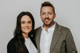 Portrait of Levi and Jennie Lusko in semiprofessional attire in front of a neutral background.