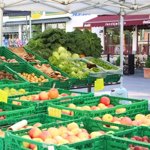 An outdoor market with fruits and vegetables on display