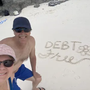 Smiling couple taking a selfie on the beach next to the words 