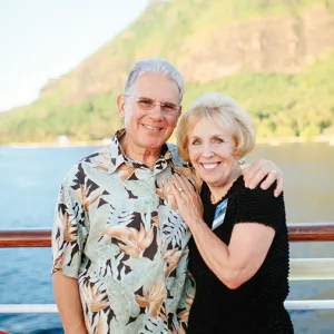 Smiling senior couple with ocean and a mountain in the background